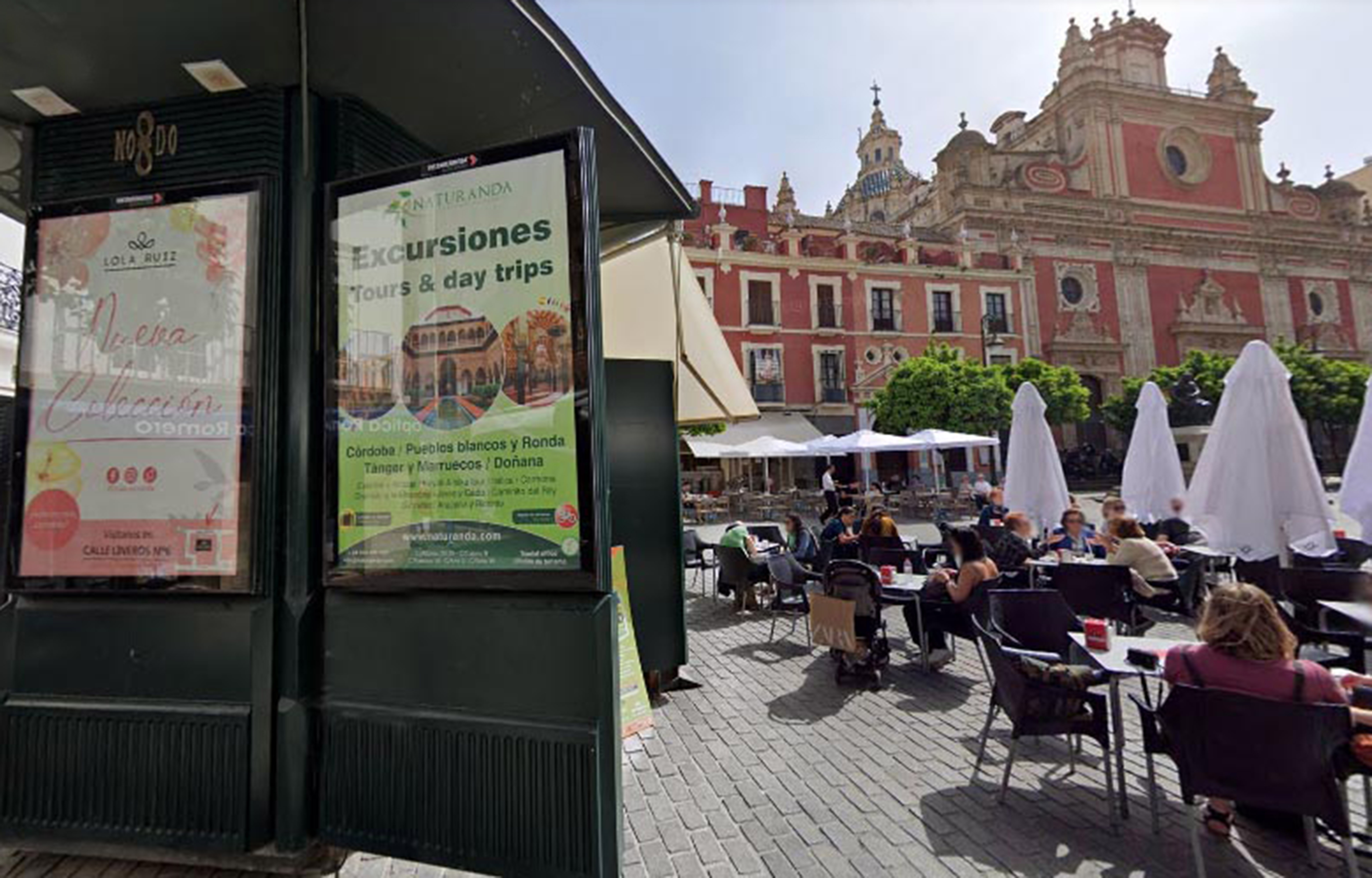 un quiosco con publicidad junto a personas