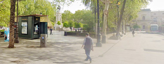 Un Kiosco con publicidad y personas en el centro de Sevilla