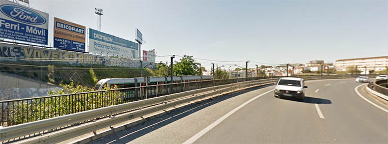 Varias vallas publicitarias junto a la carretera junto a una carretera y junto a un tren